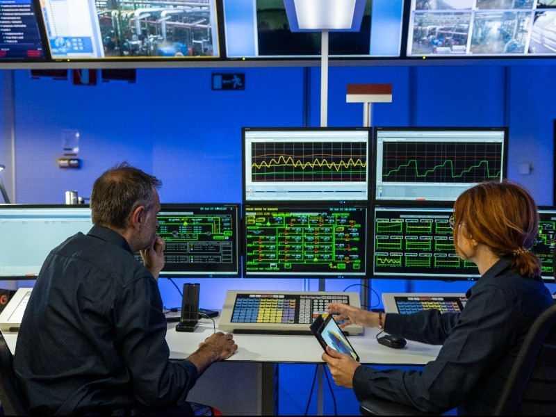 Trabajadores en una sala de control delante de pantallas